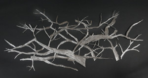 This is a wall mounted steel sculpture of multiple branch pieces.